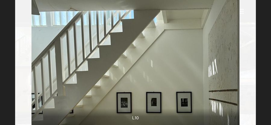 Scala interna bianca con quadri alle pareti, Case Bianche