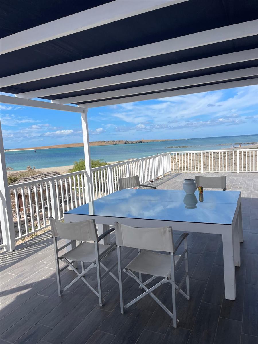 Terrazza con tavolo e sedie affacciata sul mare turchese, Case Bianche